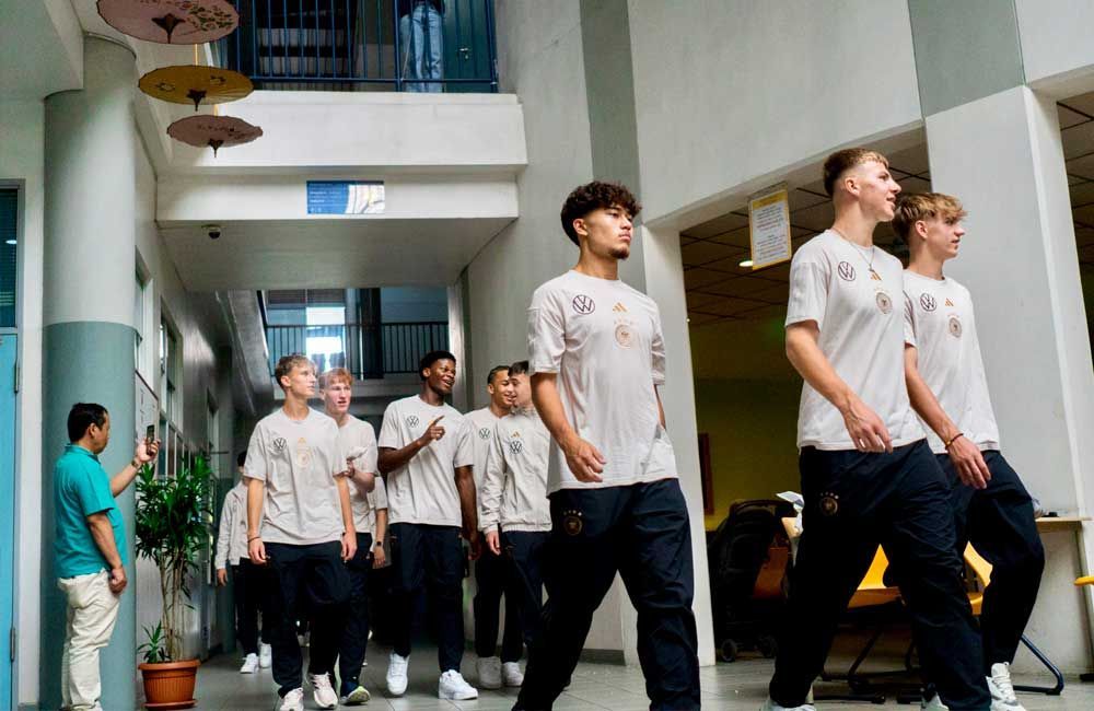 A group of young men are walking down a hallway.