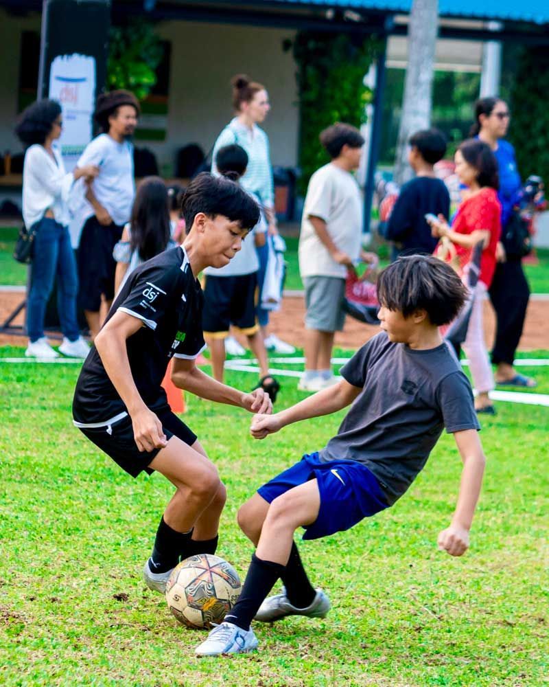 Two young boys are playing soccer on a field.