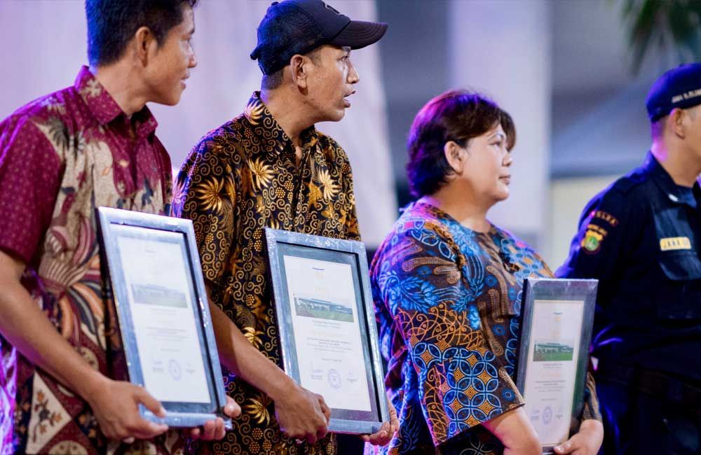 A group of people standing next to each other holding certificates.