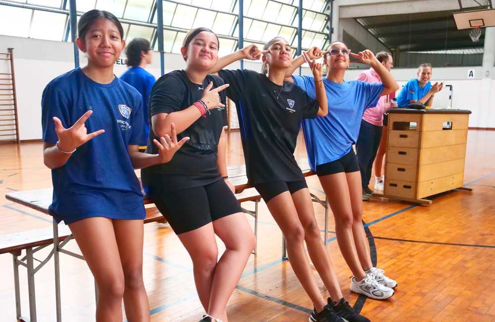 A group of young girls are posing for a picture in a gym.