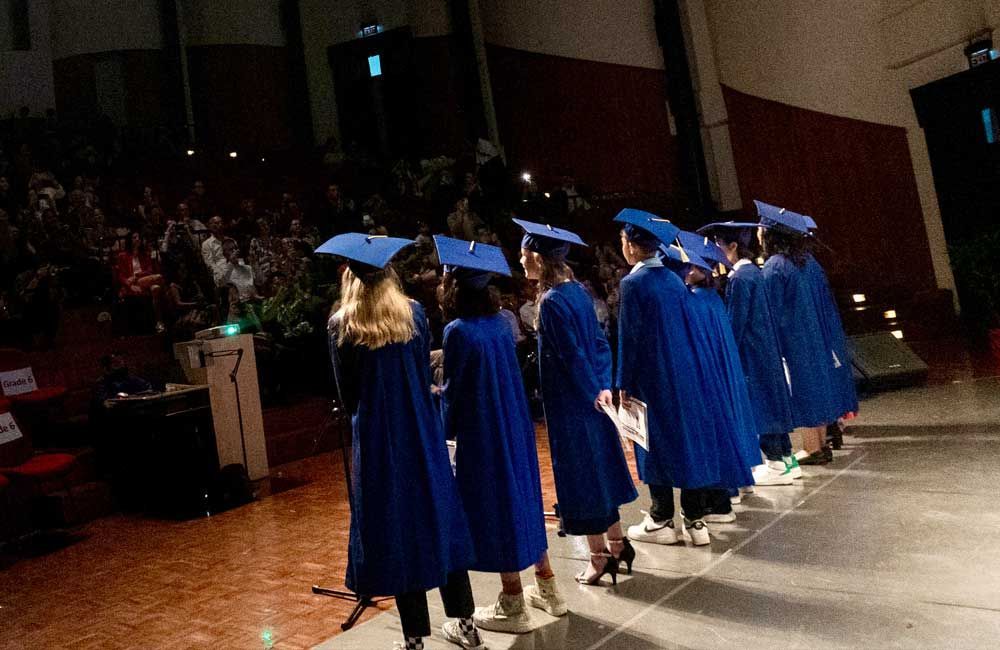 A group of graduates are walking on a stage.
