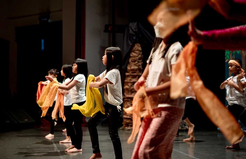 A group of young girls are dancing on a stage.