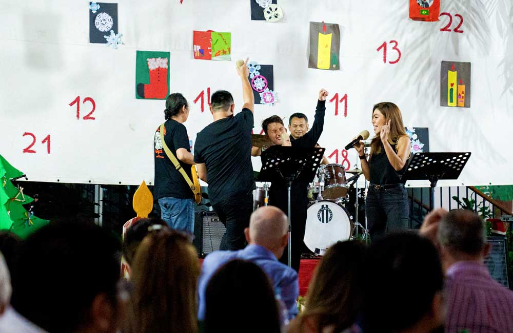 A group of people are standing on a stage in front of a wall with numbers on it.