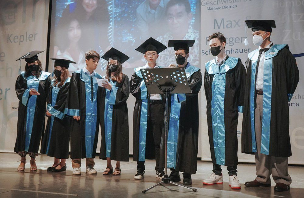 A group of graduates are standing next to each other on a stage.