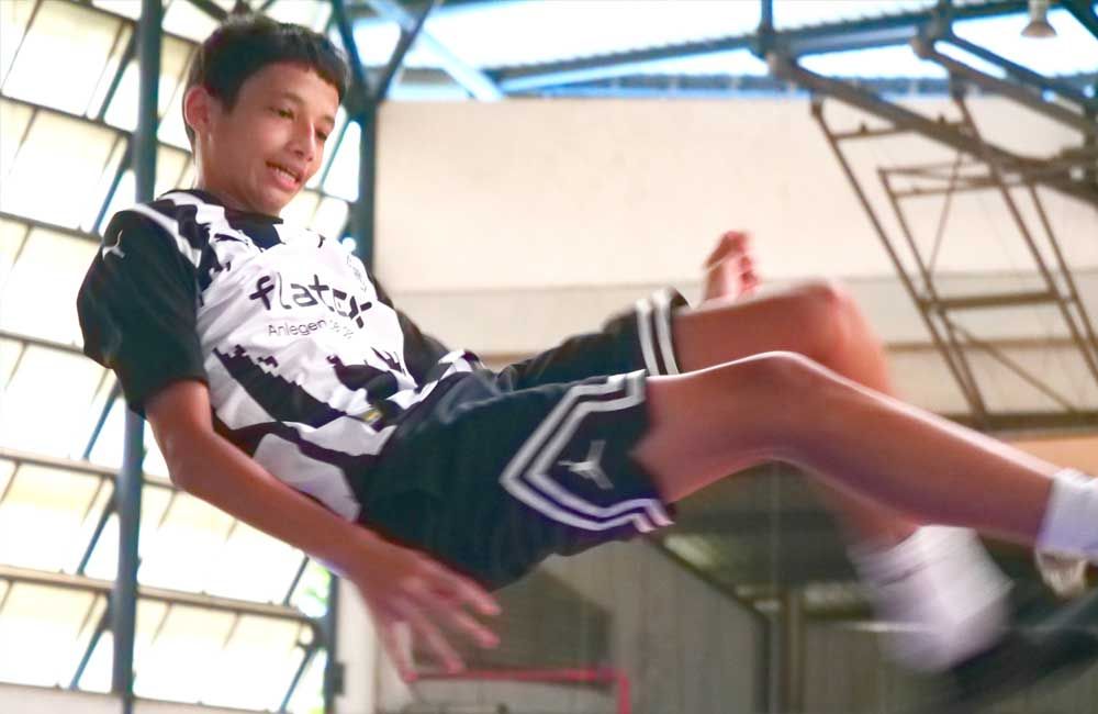 A young boy in a black and white jersey is laying on the floor.