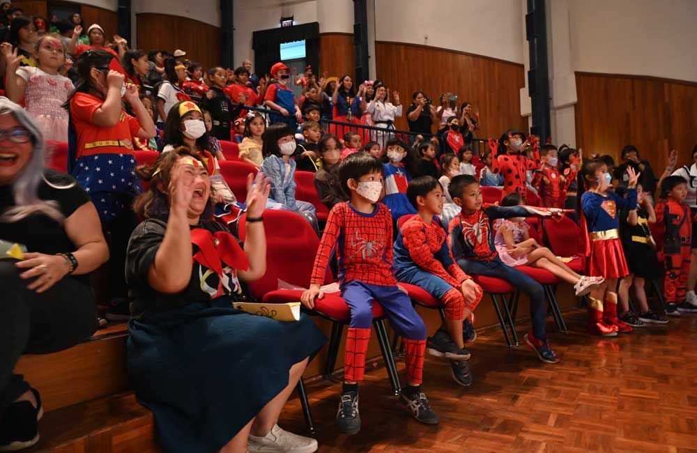 A crowd of people dressed in costumes are sitting in a theater.