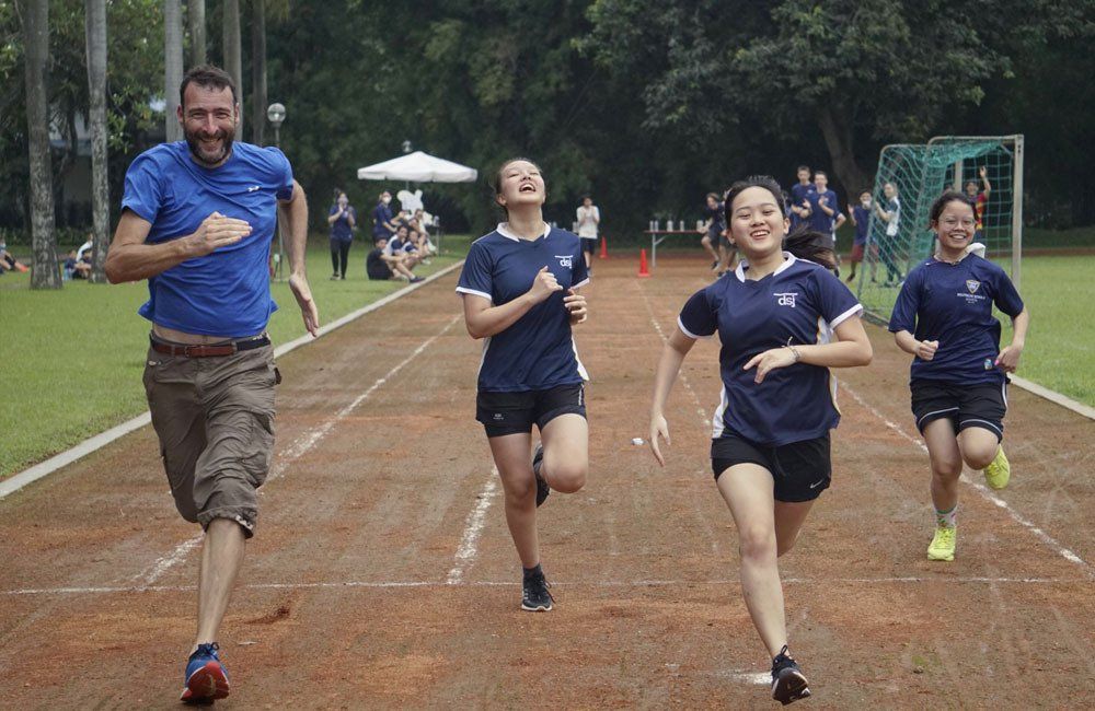 A group of people are running on a track.
