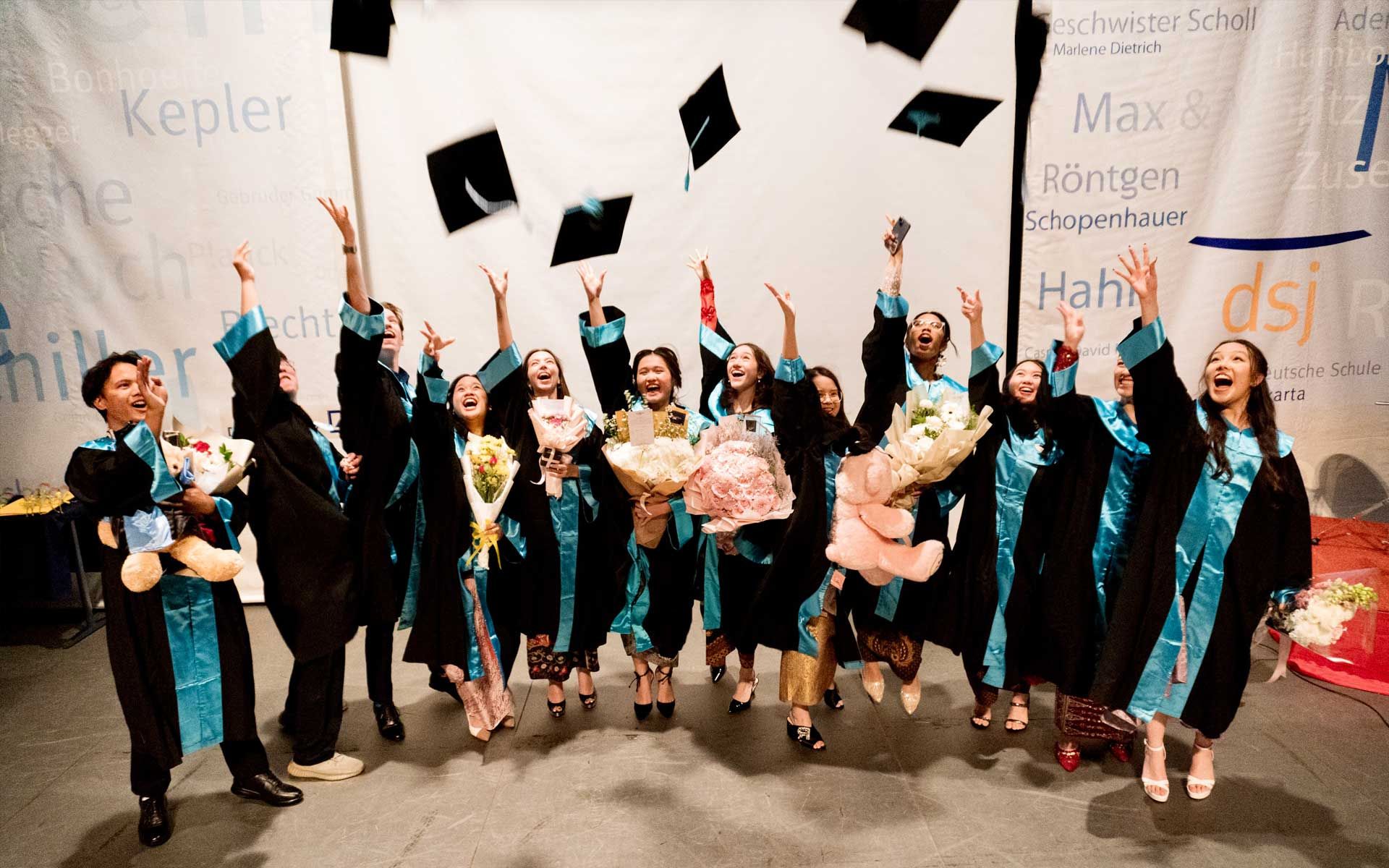 A group of graduates are throwing their caps in the air