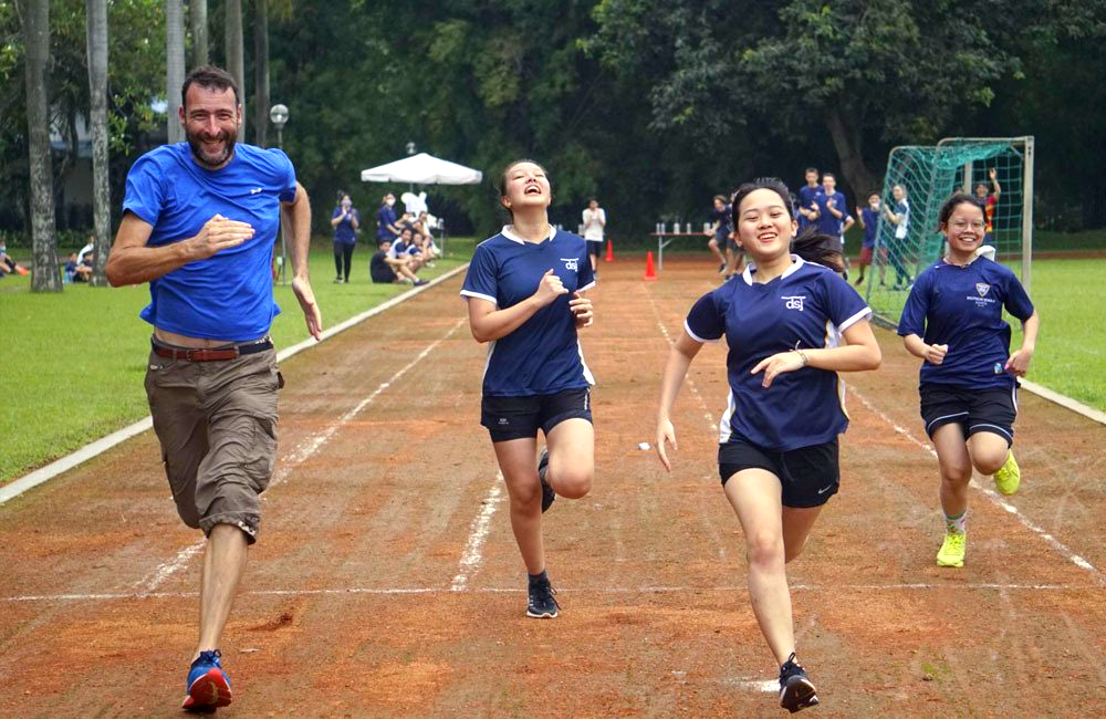 A group of people are running on a track.