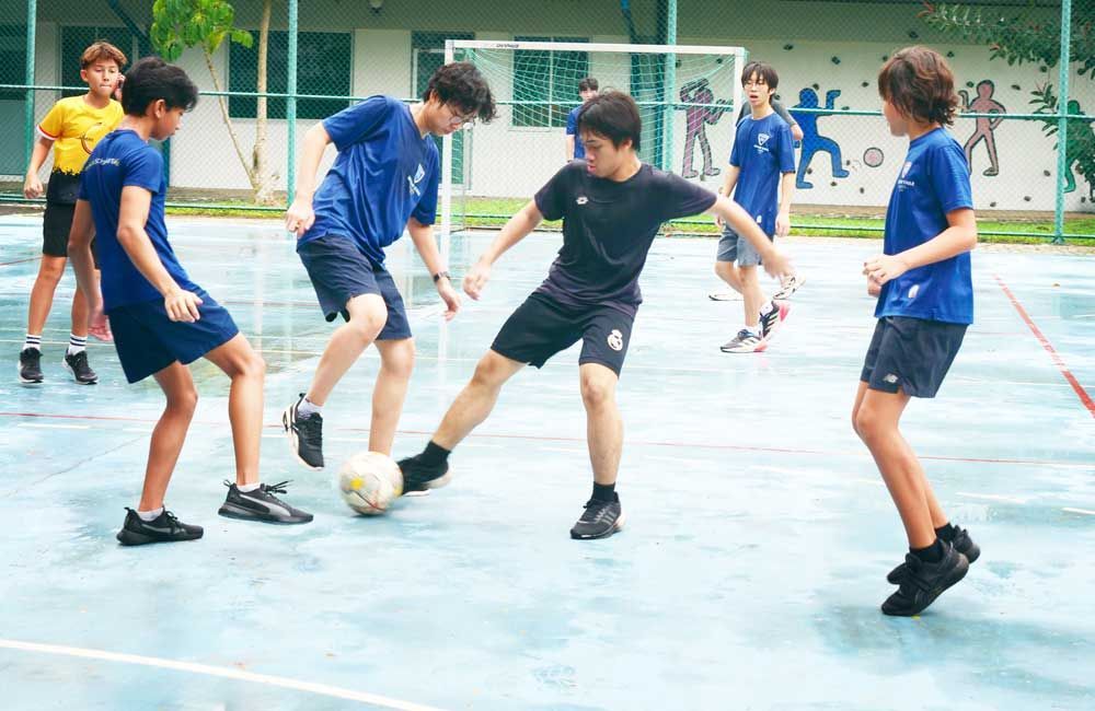 A group of young boys are playing soccer on a court.