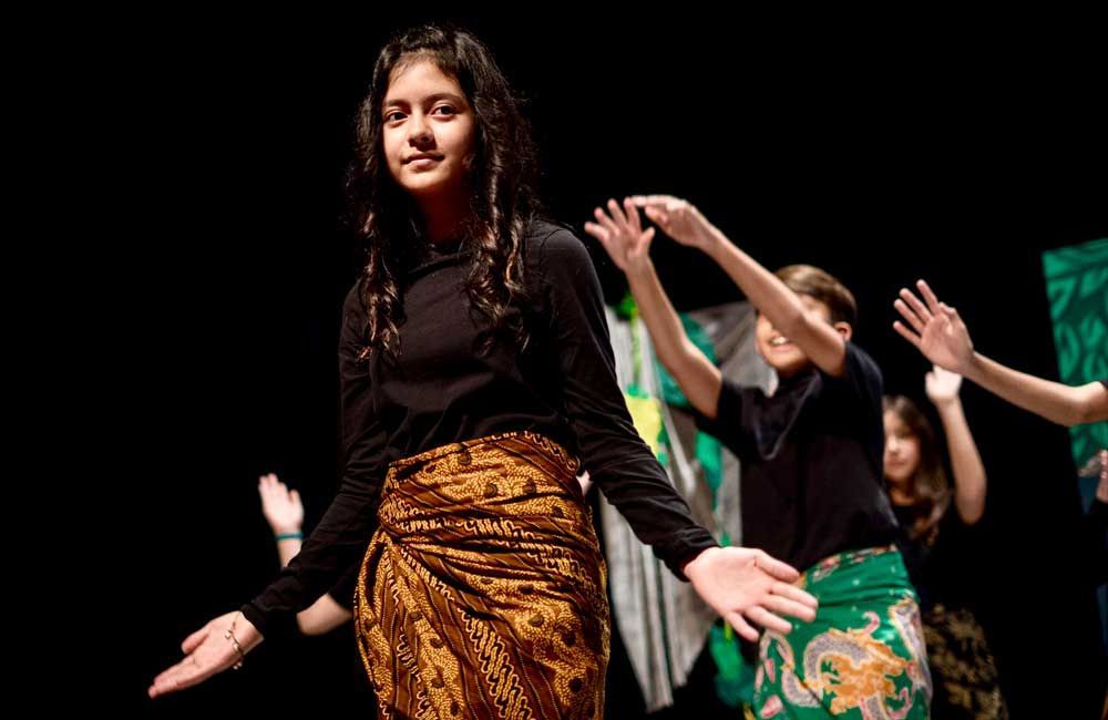 A group of young people are dancing on a stage.
