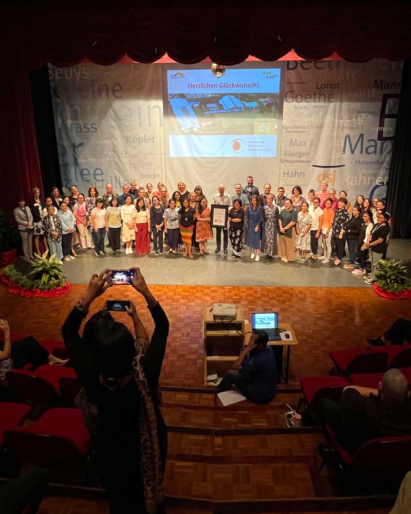 A woman is taking a picture of a group of people on a stage.