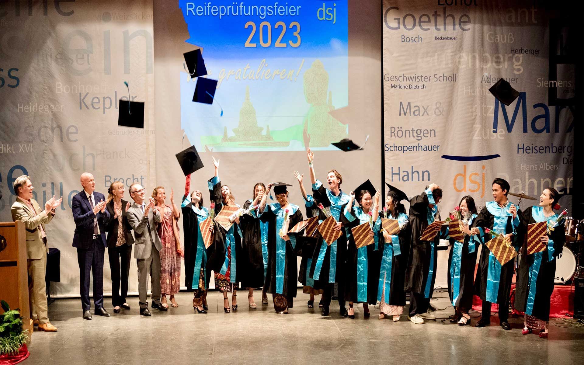 A group of graduates are throwing their caps in the air at a graduation ceremony.