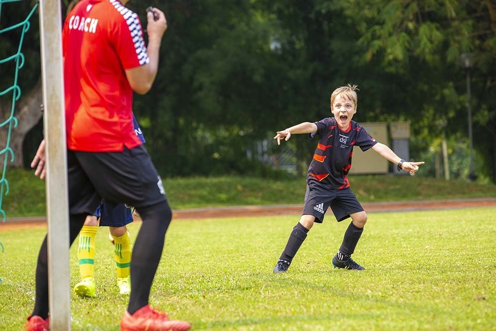 A group of young boys are playing soccer on a field.