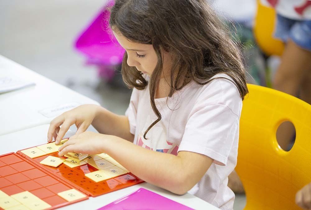 A young girl is sitting at a table playing a game.