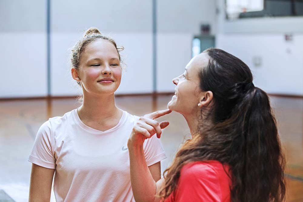 Two women are talking to each other in a gym.