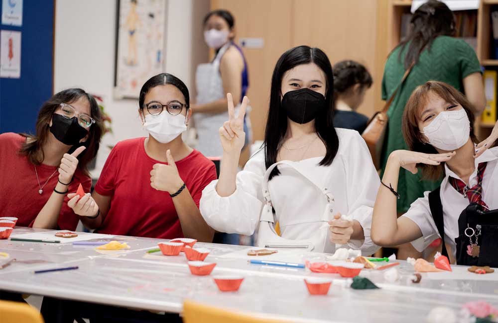 A group of young women wearing face masks are posing for a picture.