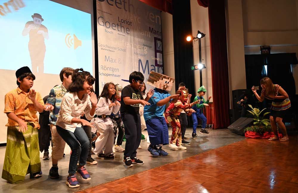 A group of children are dancing on a stage.