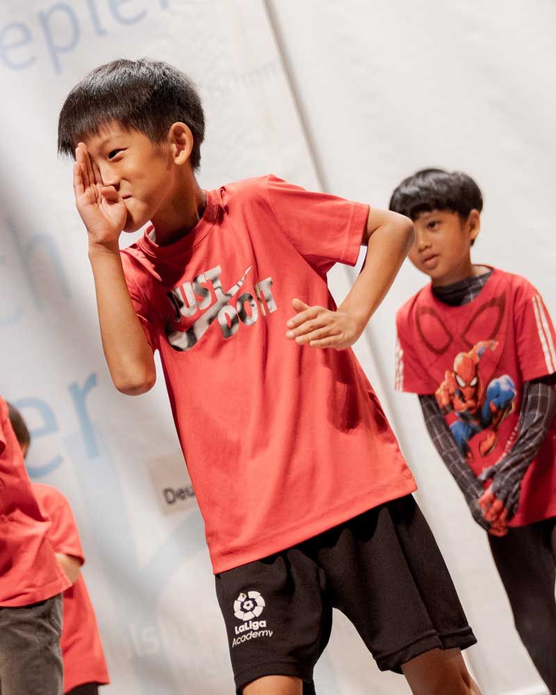 A boy in a red shirt with a spiderman on it