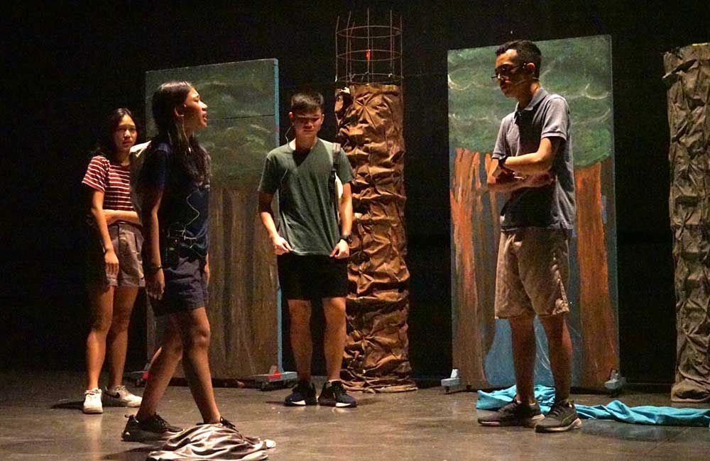 A group of people are standing on a stage talking to each other.