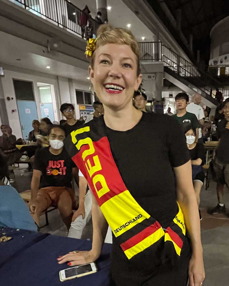 A woman wearing a sash with the word deu on it
