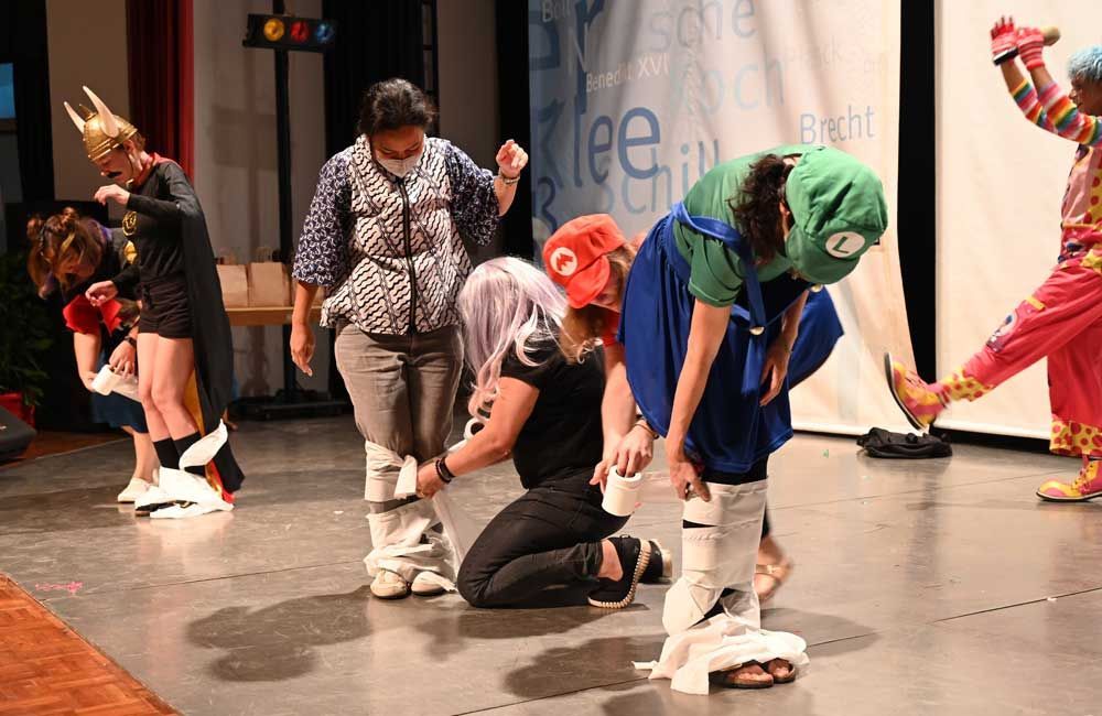 A group of people dressed in costumes are dancing on a stage.