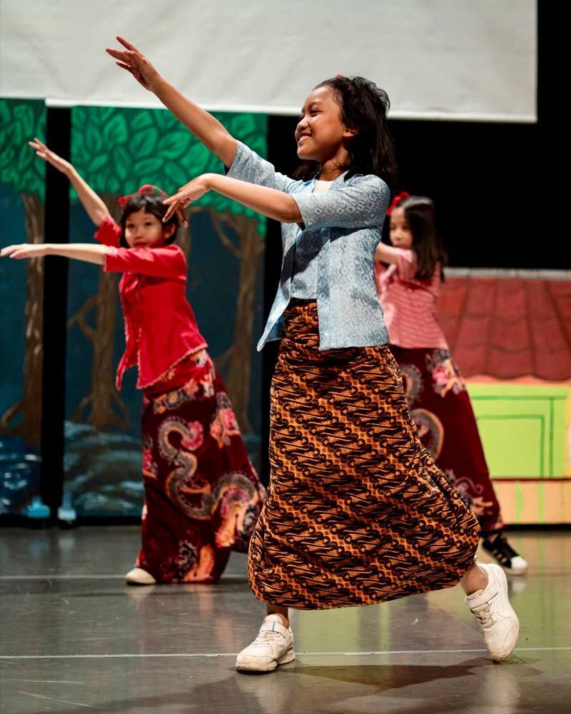 A group of young girls are dancing on a stage