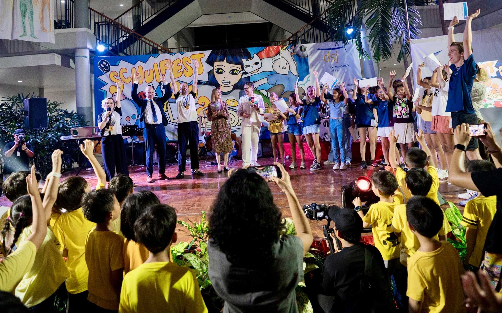 A group of people are standing in front of a stage.