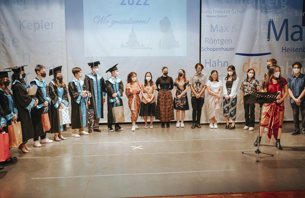 A group of people in graduation gowns are standing on a stage.