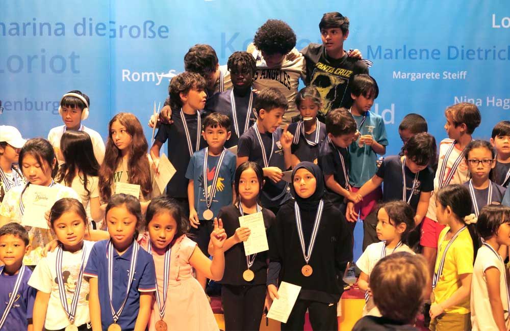 A group of children posing for a picture with medals around their necks