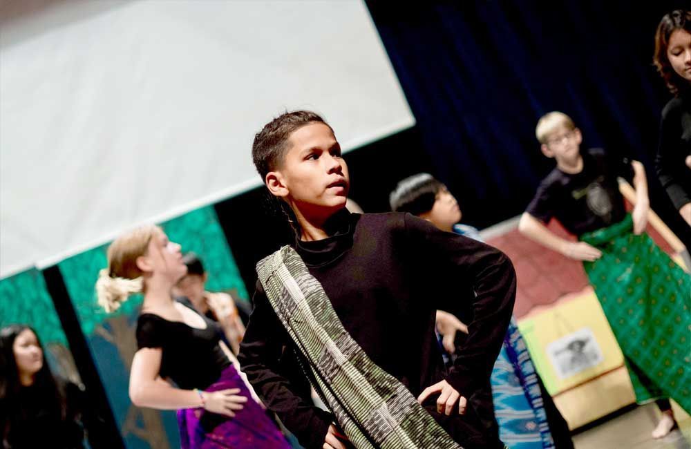 A group of children are dancing on a stage.