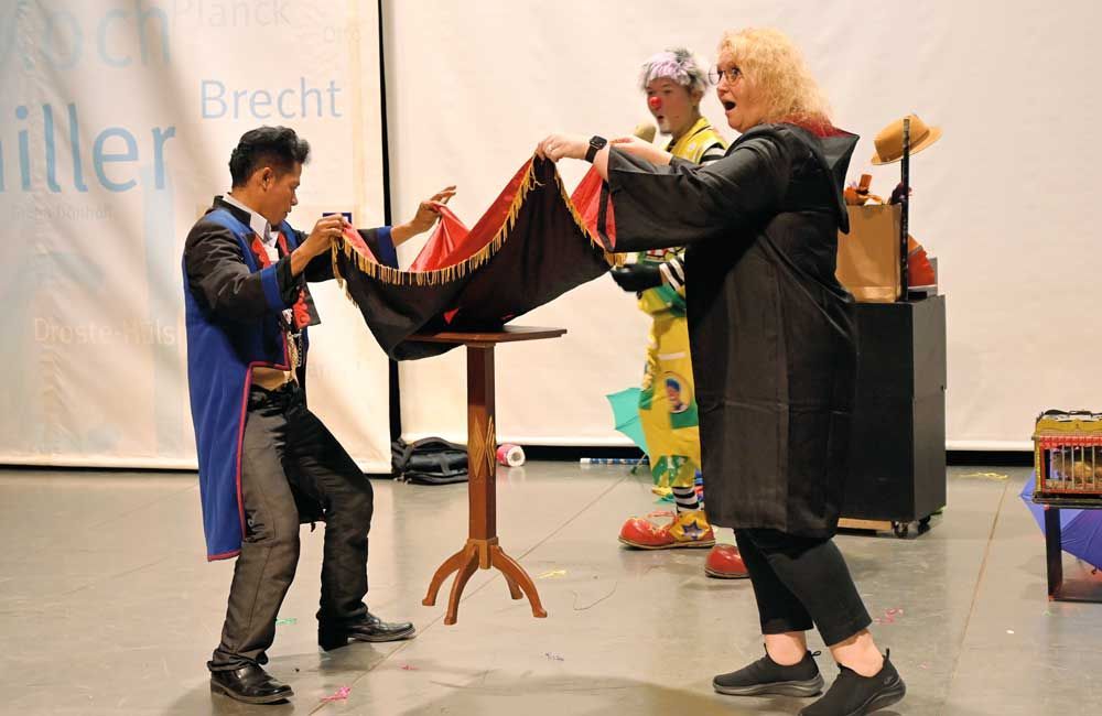 A group of people are performing a magic trick on a stage.