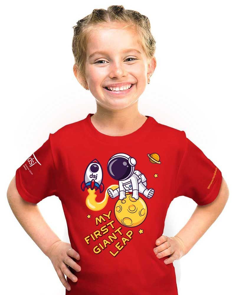 A little girl is wearing a red t-shirt with an astronaut on it.