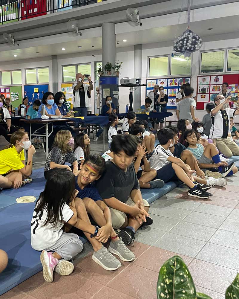 A group of children are sitting on the floor in a room.