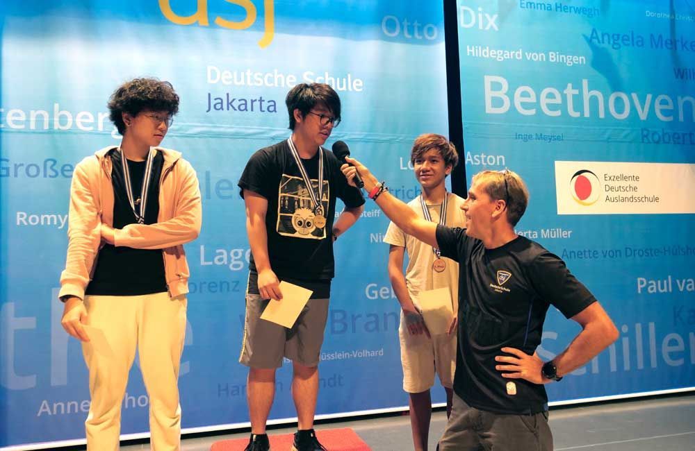 A group of young men are standing in front of a wall that says beethoven