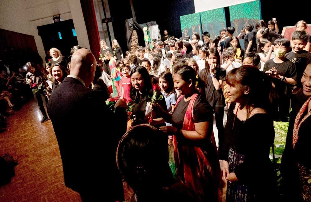 A large group of people are standing in a dark room.