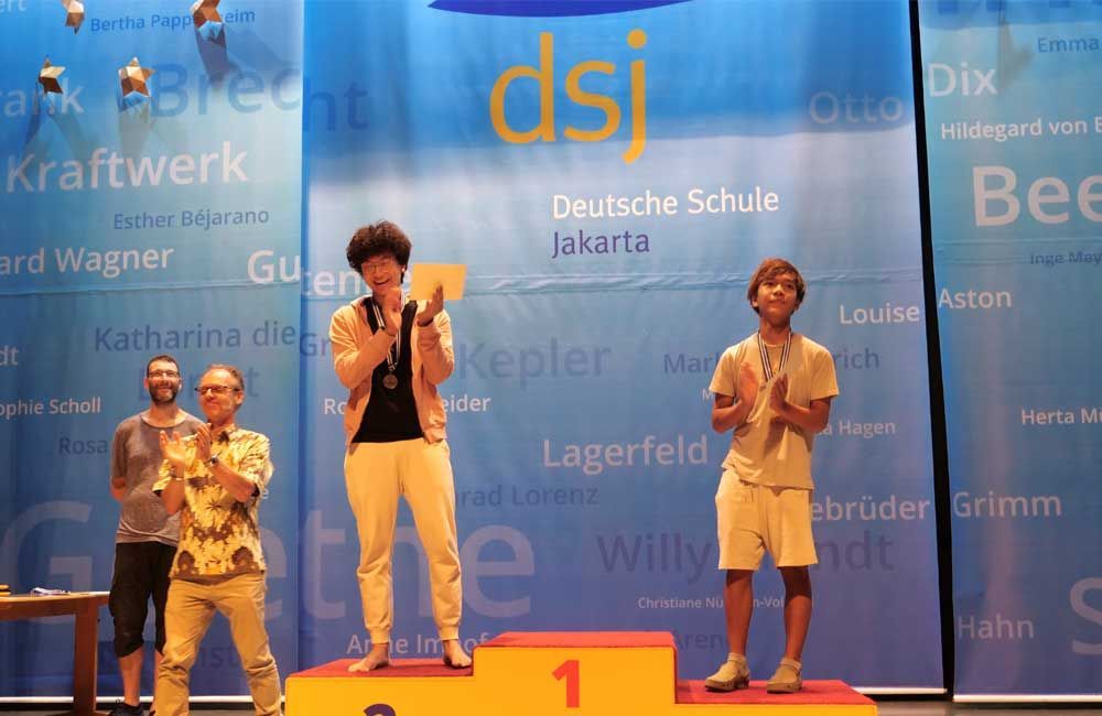 A group of people standing on a podium with the number 1 on it