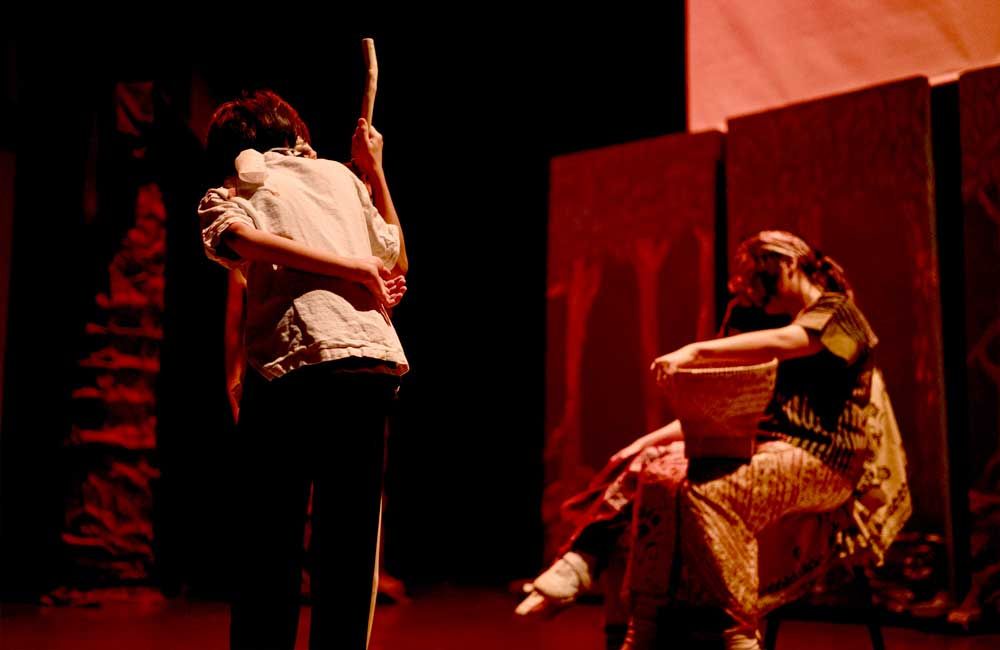 A group of people are standing on a stage in a dark room.