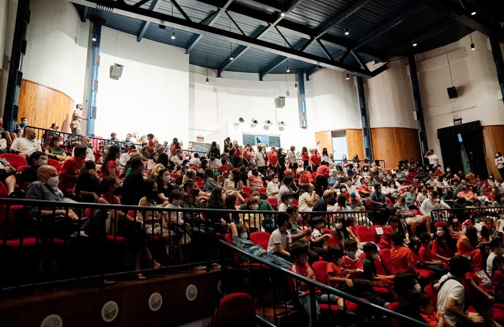 A large group of people are sitting in a large auditorium.