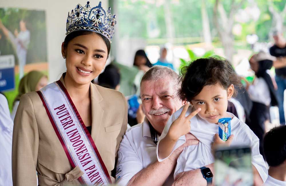 A woman in a crown is holding a child in her arms.