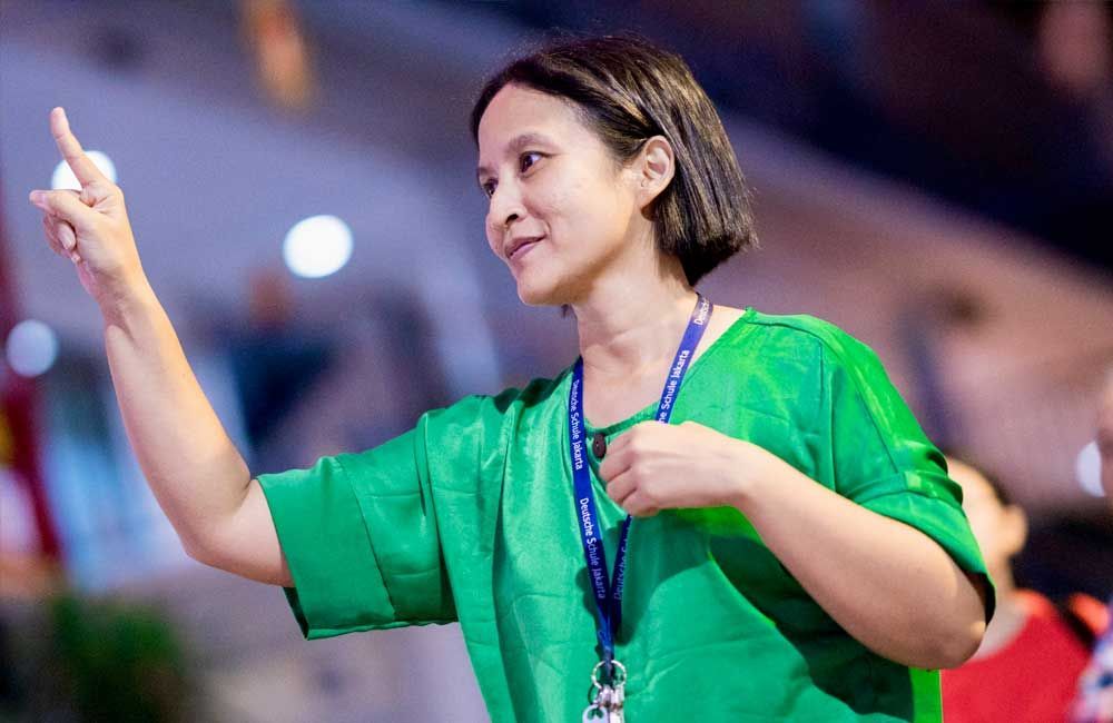 A woman in a green shirt is pointing at something.