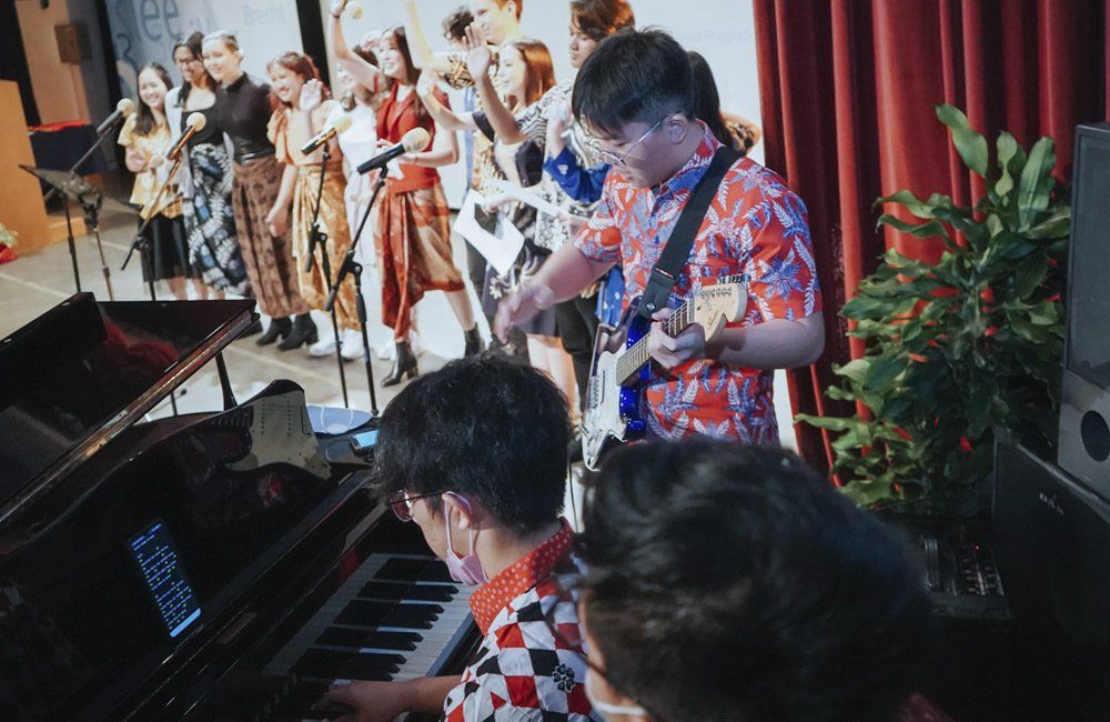 A group of people are playing instruments and singing on a stage.