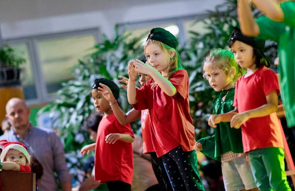 A group of young children are dancing together in a room.