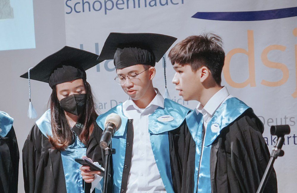 A group of graduates are standing in front of a microphone.