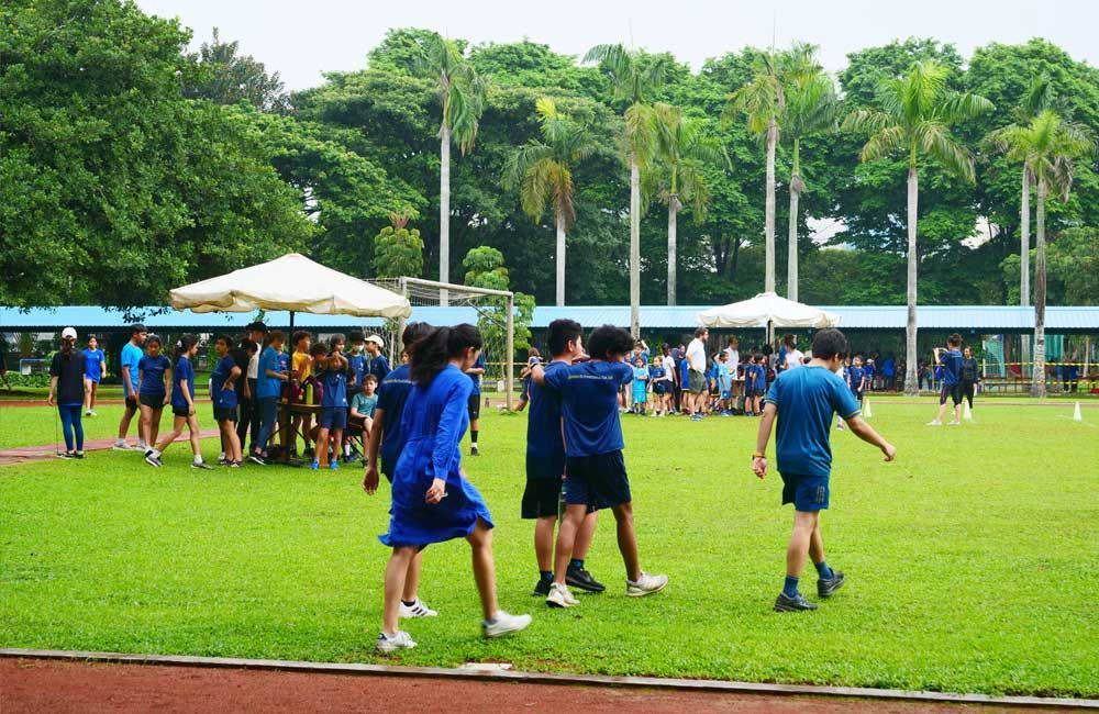 A group of people are walking on a lush green field