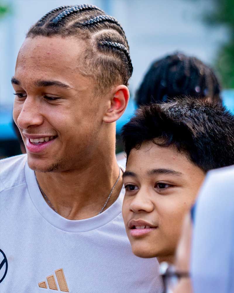 A man and a boy are standing next to each other and smiling.