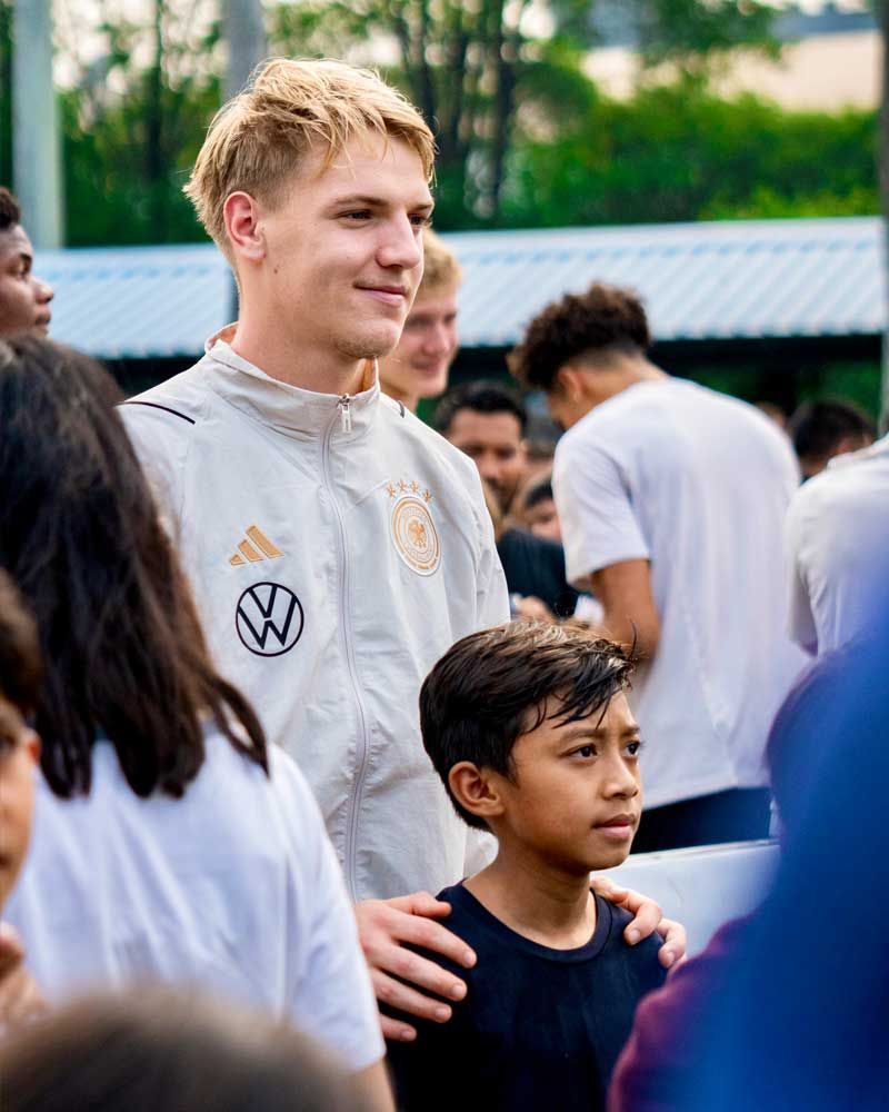 A man and a boy are standing in a crowd of people.