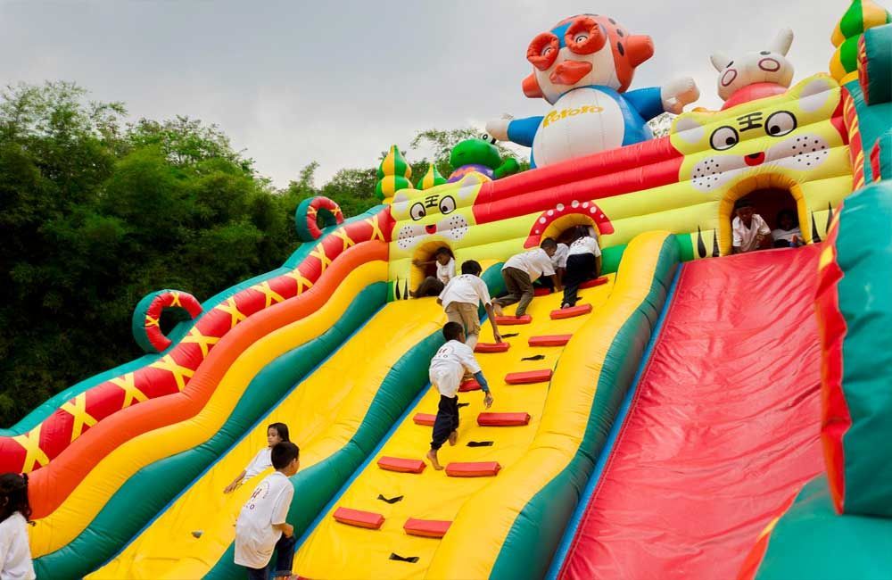 A group of children are playing on an inflatable slide.