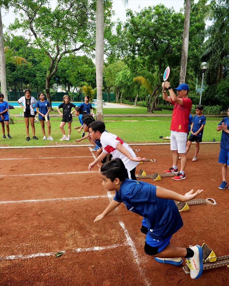 A group of children are getting ready to run on a track.