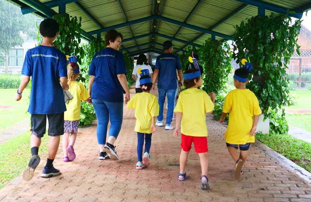 A group of children are walking down a brick walkway.